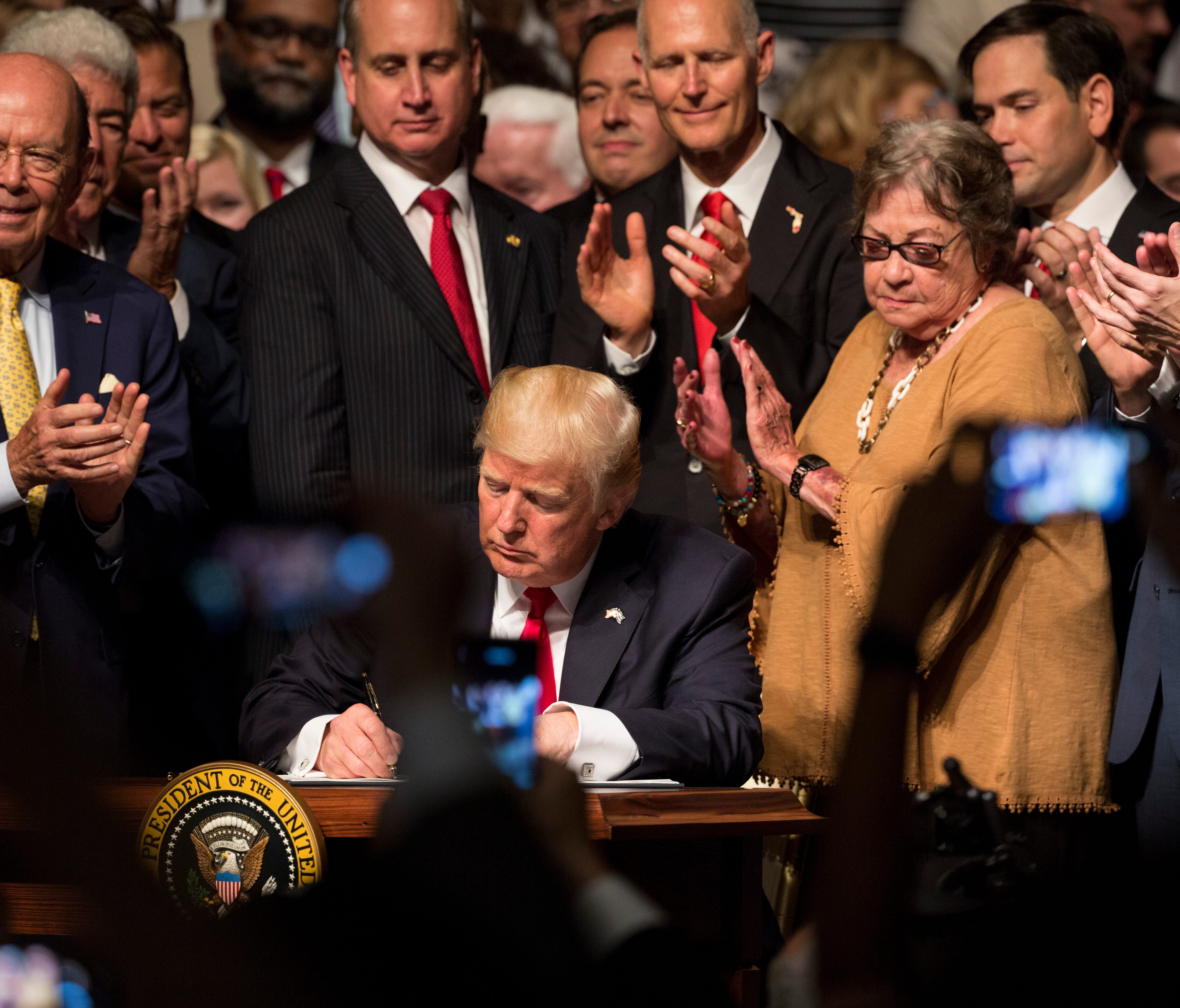 President Donald J. Trump signs his executive order regarding his Cuba policy on Friday June 16, 2017 in Miami, Florida, at Manuel Artime Theater. The executive order enforces a strict ban on tourism, calls for new reporting requirements for visitors