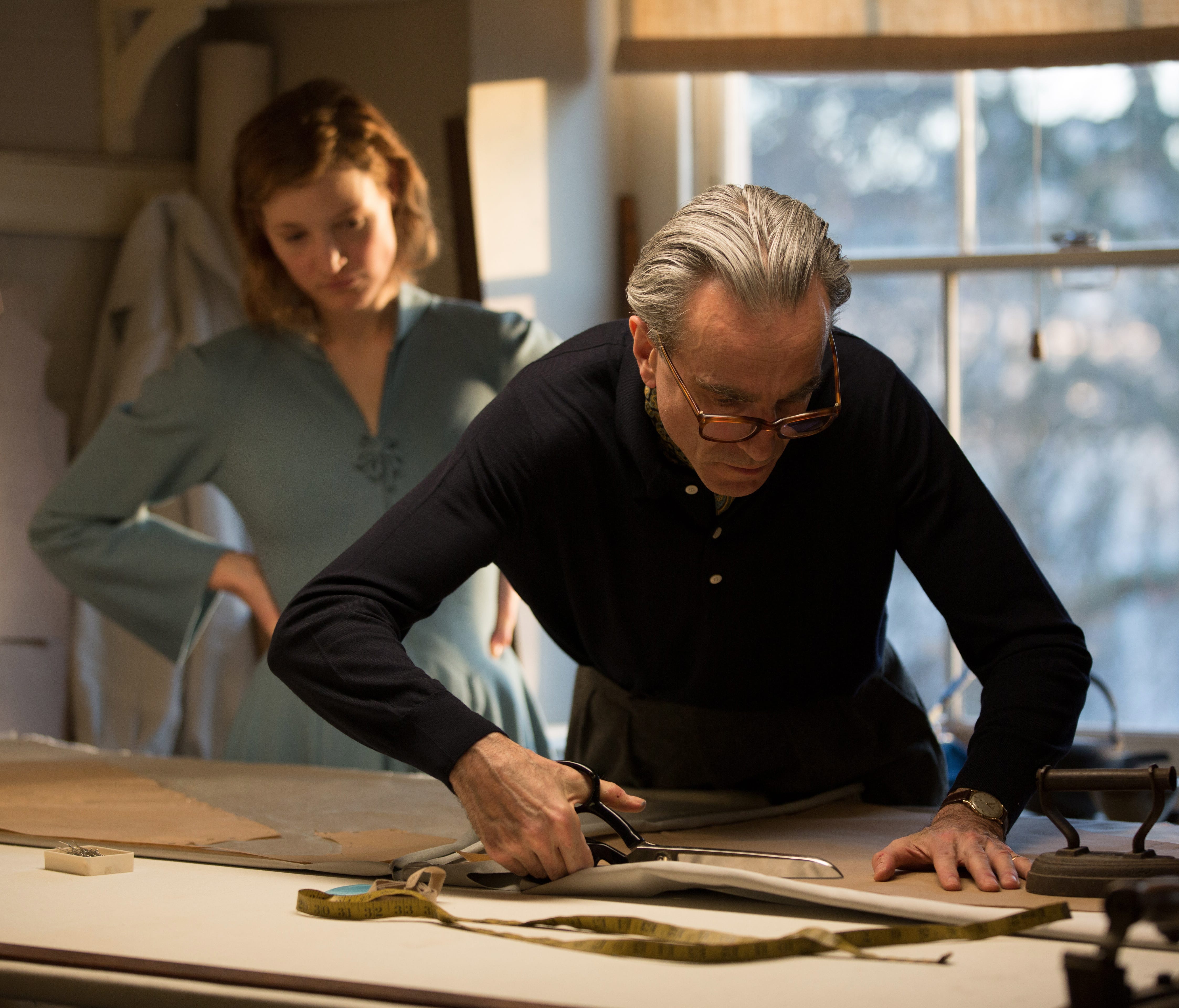 Reynolds Woodcock (Daniel Day-Lewis, right) designs a gown for his new lover and muse, Alma (Vicky Krieps).