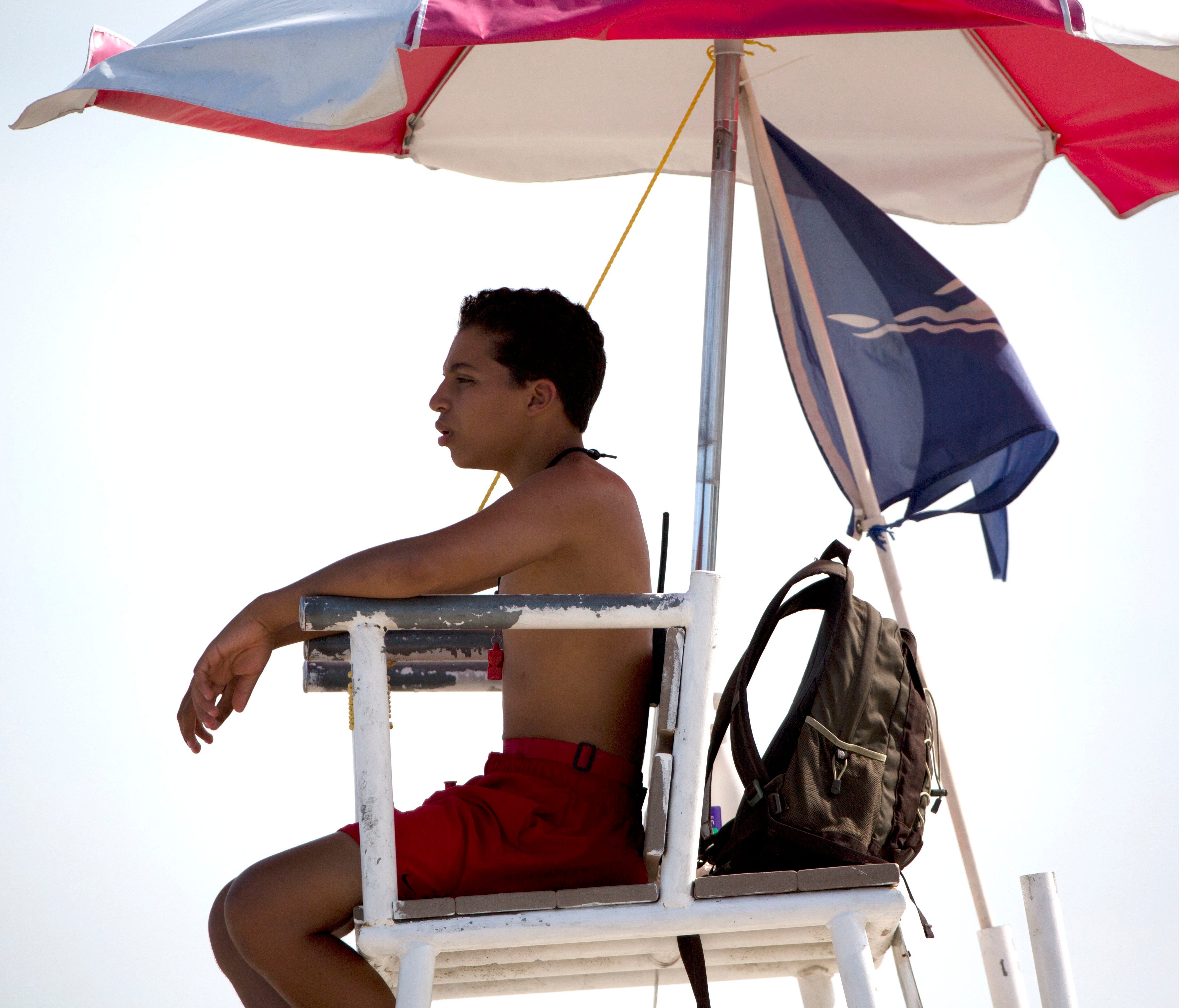 A lifeguard keeps watch at Revere Beach in Revere, Mass., Friday, July 21, 2017, in Revere, Mass. The temperature reached 90 degrees in the Boston area during the day. (AP Photo/Michael Dwyer) ORG XMIT: MAMD105