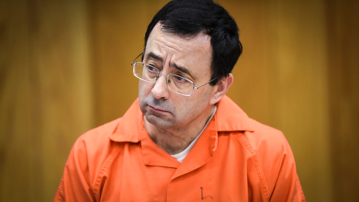 FILE - In this Feb. 2, 2018, file photo, Larry Nassar listens as Melissa Alexander Vigogne gives her victim statement in Eaton County Circuit Court in Charlotte, Mich. The U.S. Olympic Committee has fired chief of sport performance Alan Ashley in the wake of an independent report that said neither he nor former CEO Scott Blackmun elevated concerns about the Larry Nassar sexual abuse allegations when they were first reported to   them. The 233-page independent report was released Monday, Dec. 10, 2018. It detailed an overall lack of response when the USOC leaders first heard about the Nassar allegations from the then-president of USA Gymnastics, Steve Penny. Blackmun resigned in February because of health concerns.(Matthew Dae Smith/Lansing State Journal via AP, File)