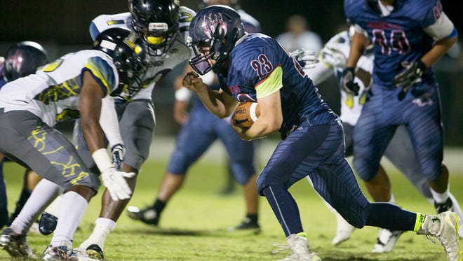 Estero High School’s Jonathan Rauss takes on Lehigh  defenders during second quarter play on Friday at Estero High School.