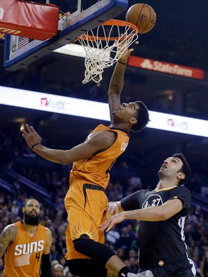 Suns' Marquese Chriss lays up a shot over Warriors' Zaza Pachulia during the first half, Saturday, Dec. 3, 2016, in Oakland, Calif.