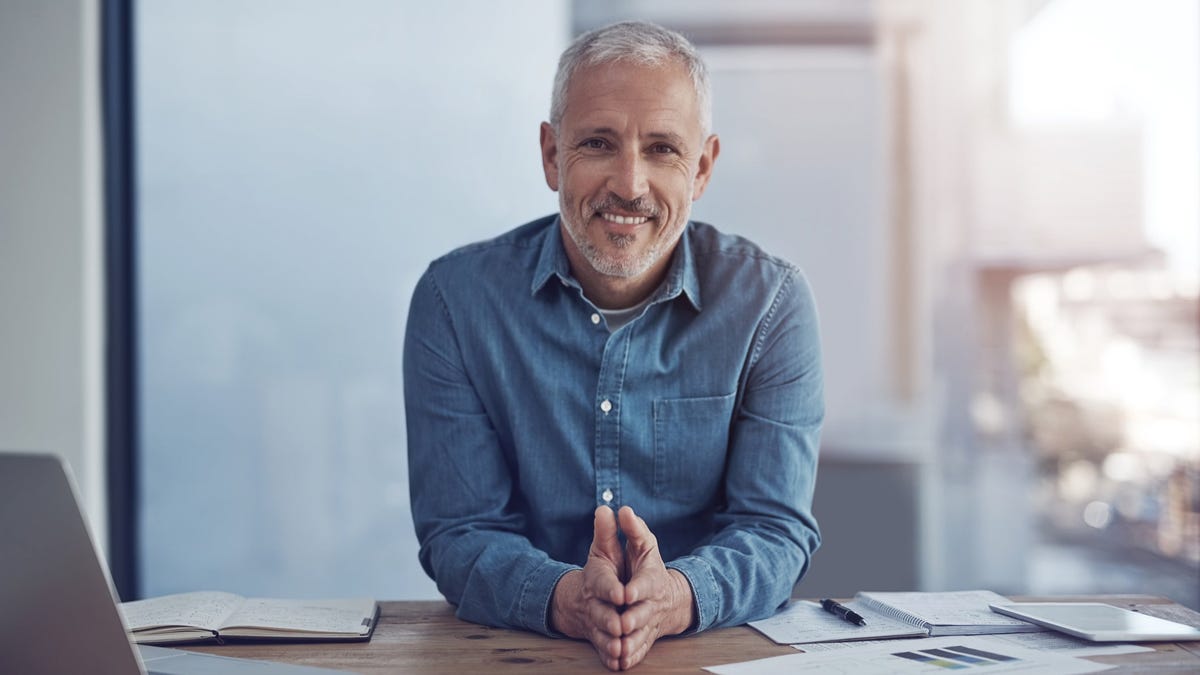 A smiling person at a desk.