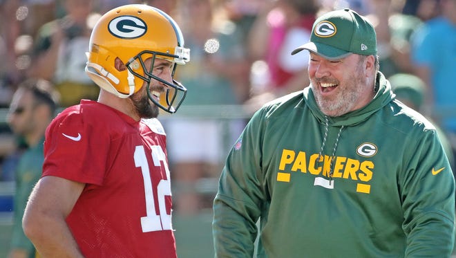 Green Bay Packers quarterback Aaron Rodgers (12) listens as head coach Mike McCarthy tells a funny story during Green Bay Packers Training Camp Saturday, July 29, 2017 at Ray Nitschke Field in Ashwaubenon, Wis.