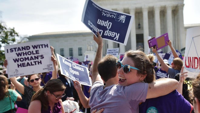 Abortion rights activists embrace Monday after the U.S. Supreme Court struck down a Texas law placing restrictions on abortion clinics.