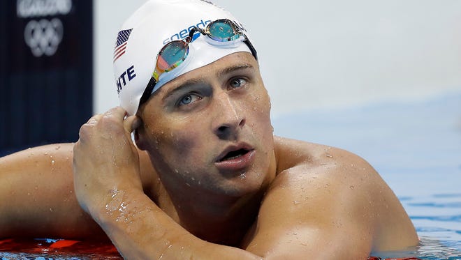In this Tuesday, Aug. 9, 2016, file photo, United States' Ryan Lochte checks his time in a men's 4x200-meter freestyle heat during the swimming competitions at the 2016 Summer Olympics, in Rio de Janeiro, Brazil. Lochte and three other American swimmers were robbed at gunpoint early Sunday, Aug. 14, by thieves posing as police officers who stopped their taxi and took their money and belongings, the U.S. Olympic Committee said.