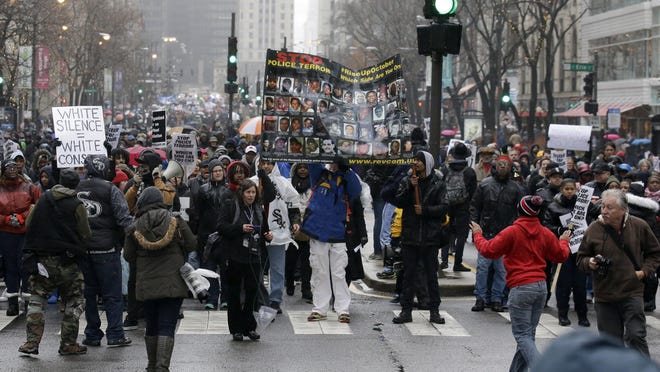Protesters make their way up North Michigan Avenue on Friday, Nov. 27, 2015, in Chicago as community activists and labor leaders hold a demonstration billed as a "march for justice" in the wake of the release of video showing an officer fatally shooting Laquan McDonald. (AP Photo/Nam Y. Huh)