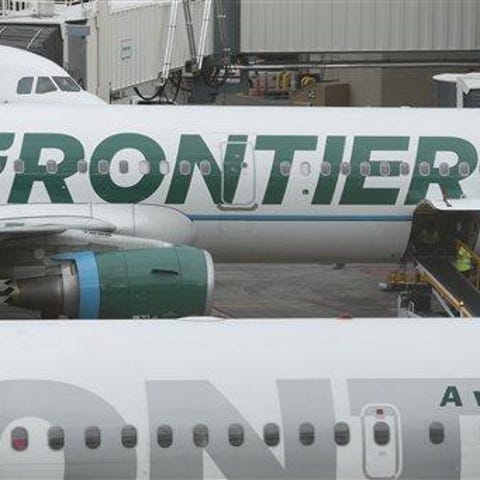 A Frontier Airlines airplane waiting at a gate at 