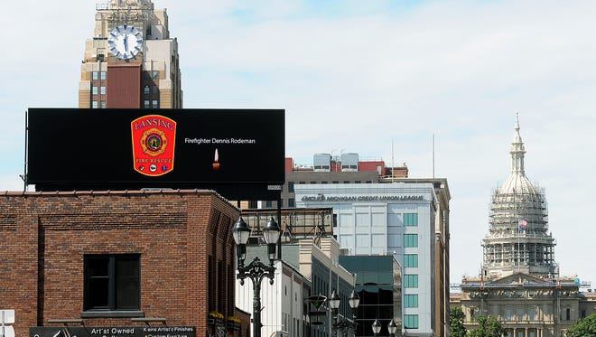 A tribute to fallen firefighter Dennis Rodeman is displayed on the digital billboard on Michigan Avenue in downtown Lansing Thursday. Rodeman was killed Wednesday when he was struck by a vehicle collecting donations for the "Fill the Boot" campaign.