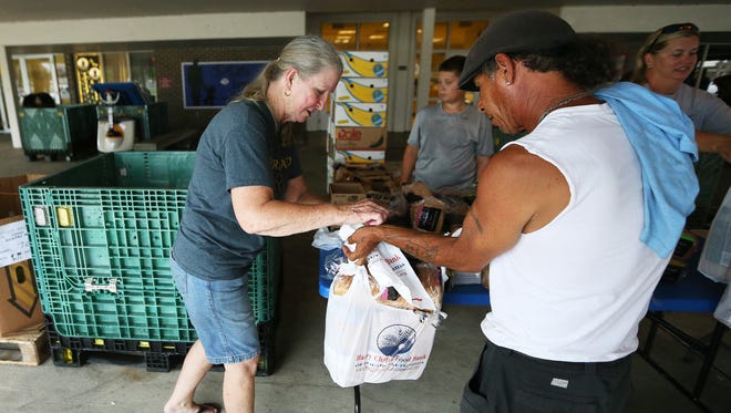 Barbara Scruggs, left, gives out food recently from Harry Chapin Food Bank’s mobile pantry at Moore Haven Elementary School in Glades County. Glades has no grocery stores. There are more than 125 food deserts in the 5-county area of Lee, Collier, Charlotte, Hendry and Glades.