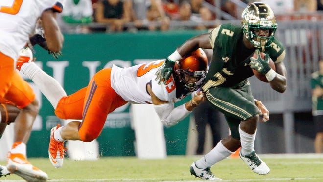 D'Ernest Johnson of the South Florida Bulls is dragged down by linebacker Tre Watson of the Illinois Fighting Illini on Friday night.