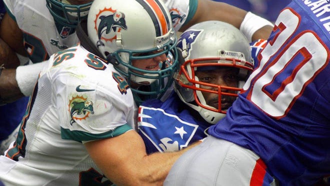 Dolphins linebacker Zach Thomas stops New England's Terry Allen in 1999.