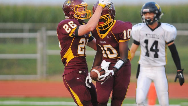 Harrisburg's Dylan Tams (28) and Paul Paul (10) react after Paul scored a touchdown during a game against Mitchell Saturday, Aug. 29, 2015, at the Harrisburg High School in Harrisburg, S.D. 