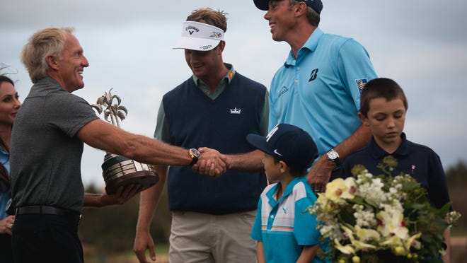 Tournament host Greg Norman, left, presents the Franklin Templeton Shootout trophy to teammates Harris English, middle, and Matt Kuchar at Tiburón Golf Club at The Ritz-Carlton Golf Resort last December.