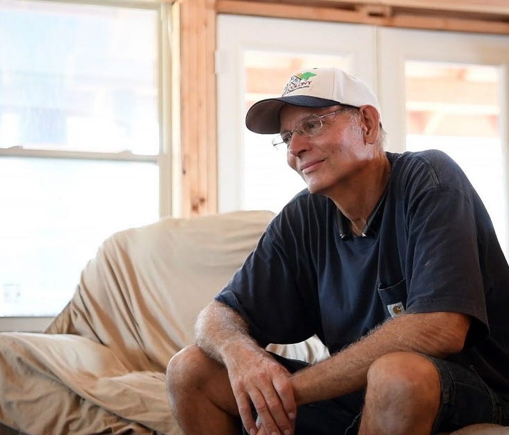 Tom Powell takes a moment to thank his sons and their friends for helping them clean out his new home, still under construction, which sits on the hill above his flooded cottage. Powell visited the home to see the extensive flooding after Hurricane H
