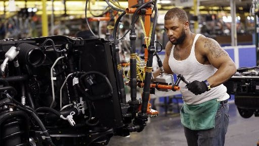 Stephen Carpenter works on an outside temperature gauge for a new SUV at the General Motors plant in Arlington, Texas.