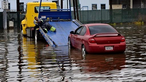 A tow driver attempts to retrieve a stalled car at a flooded park and ride lot on Tuesday in Mill Valley, Calif. A weather pattern that could be associated with El Nino has turned winter upside-down across the U.S. during a week of heavy holiday travel, bringing spring-like warmth to the Northeast, a risk of tornadoes in the South and so much snow in parts of the West that there are concerns about avalanches.