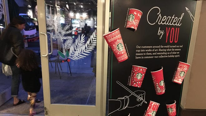 In this Tuesday, Nov. 8, 2016, photo, Starbucks holiday cups appear on display at a store in New York.