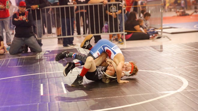 Degan Lake of Dolores, Colo., gets Denver's Isaac Garcia into a headlock during at 8U match at the Aztec Warrior Championships Saturday at McGee Park Convention Center in Farmington. Visit daily-times.com to see video highlights from the event.