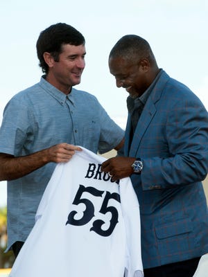Bubba Watson presents Derrick Brooks with his very own Blue Wahoos jersey during a ceremony announcing Brooks’ as a new co-owner of minor league baseball team on Wednesday, May 23, 2018. 