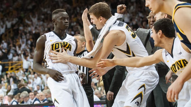 Iowa Hawkeyes guard Peter Jok (14) is congratulated by center Adam Woodbury (34) and the Iowa bench during the second half against the Michigan Wolverines at Carver-Hawkeye Arena. Iowa won 82-71.