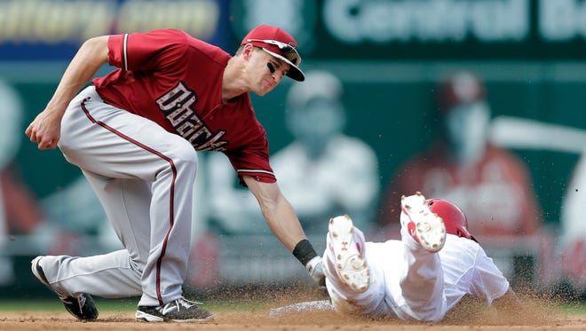 St. Louis Cardinals' Kolten Wong, right, is tagged out by Arizona Diamondbacks shortstop Nick Ahmed while attempting to steal second during the fifth inning of a baseball game Monday, May 25, 2015, in St. Louis.