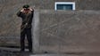 A North Korean soldier uses his binoculars on the banks