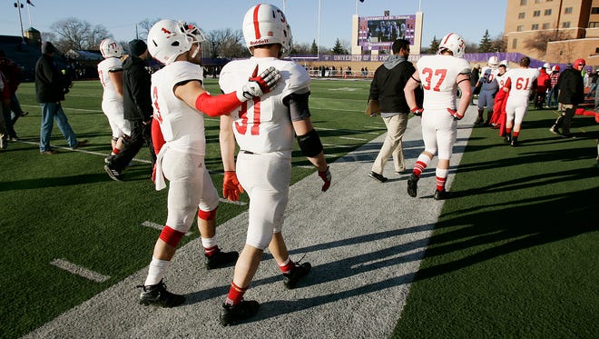 St. John's players and coaches walk to the locker room after their loss to St. Thomas.