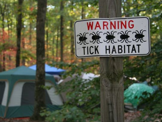 A sign warns of ticks in the area.