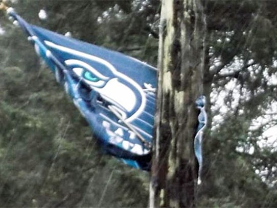 A Seahawks flag flaps in the wind and rain in Seattle.