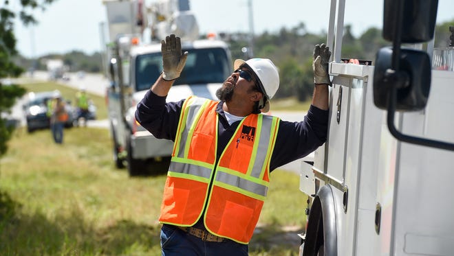 Pacific Gas and Electric Company worker Jose Tirado of San Luis Obispo, California assesses a fallen power line pole Wednesday, Sept. 13, 2017, before working to hoist it just south of the Hobe Sound National Wildlife Refuge off of U.S. Highway One in Hobe Sound. To see more photos, got to TCPalm.com. CQ: Jose Tirado