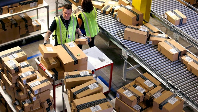 FILE - In this Dec. 2, 2013 file photo, Amazon.com employees organize outbound packages at an Amazon.com Fulfillment Center on "Cyber Monday" the busiest online shopping day of the holiday season, in Phoenix. Buying things online could soon get pricier for many people after the U.S. Supreme Court's decision Monday, Dec. 12, 2016, not to get involved in a case that may lead to states collecting billions in lost sales taxes.
