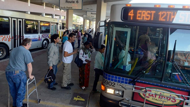 
Passengers wait in line to board a bus in 2013.
