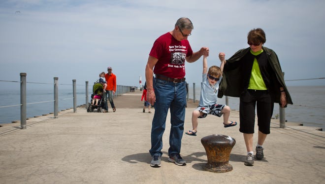 Dave and Liz Brazofsky, who were visiting from Ohio, lift up their grandson, Seth, while walking down the pier at Ontario Beach Park on Sunday May 24, 2015.