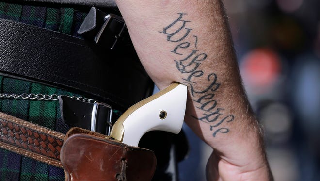 In this Jan. 26, 2015, file photo, Scott Smith, a supporter of open carry gun laws, wears a pistol as he prepares for a rally in support of open carry gun laws at the Capitol, in Austin, Texas. Despite its reputation as the trigger-happy heart of American gun culture, Texas is late to the open carry party, at least when it comes to handguns. On New Yearís Day, itíll become the 45th state to legalize carrying a pistol in plain sight. (AP Photo/Eric Gay, File) ORG XMIT: CX106