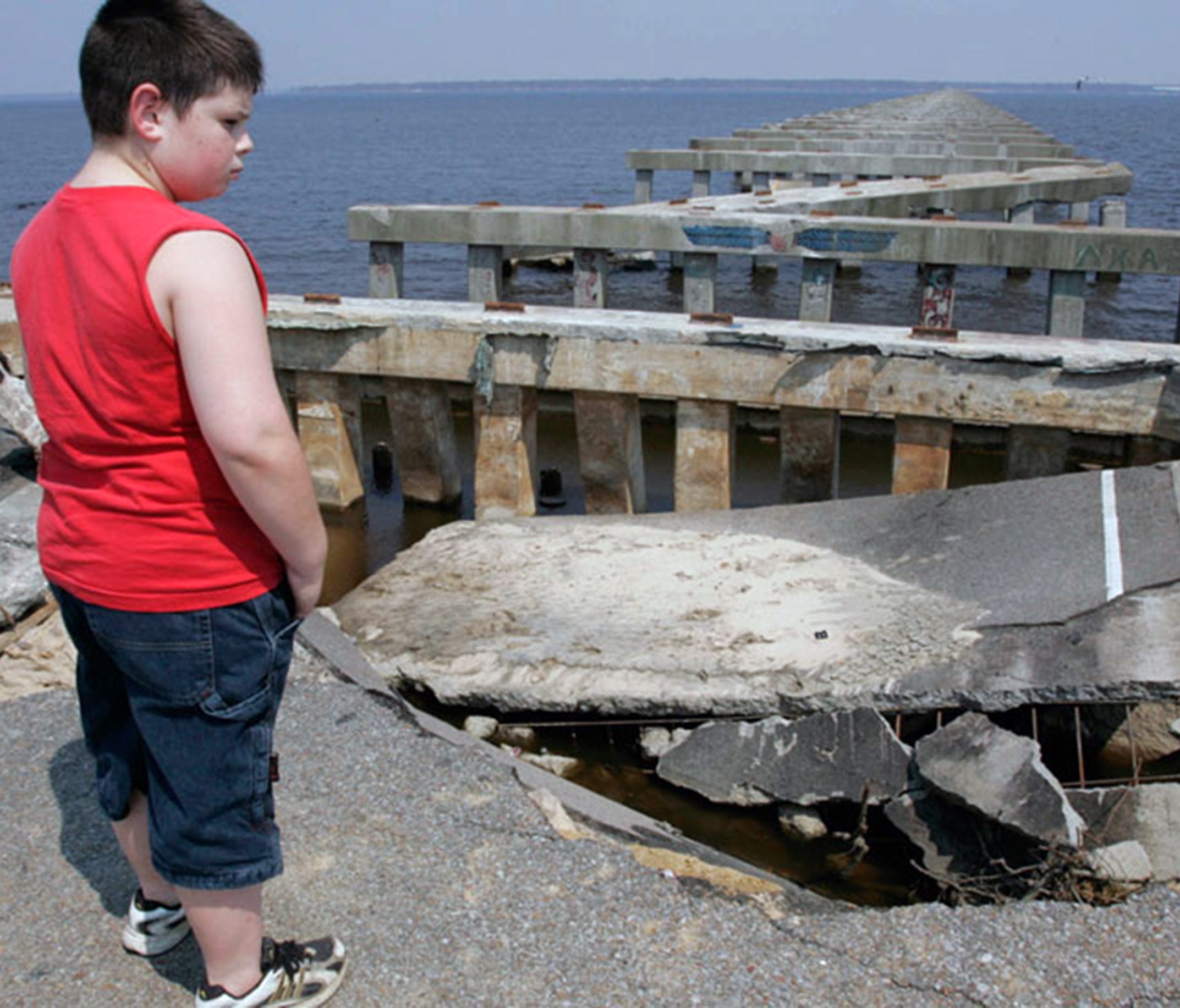 Mike Garvin, 11, of Baton Rouge, La., looks Sept. 4, 2005, at the ruins of the U.S. 90 bridge over Bay St. Louis, destroyed in Hurricane Katrina.