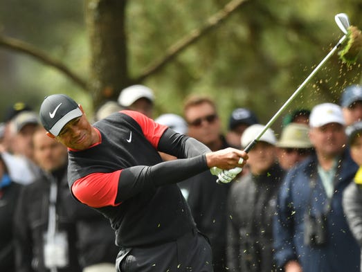Tiger Woods hits from the fairway on the 1st hole during