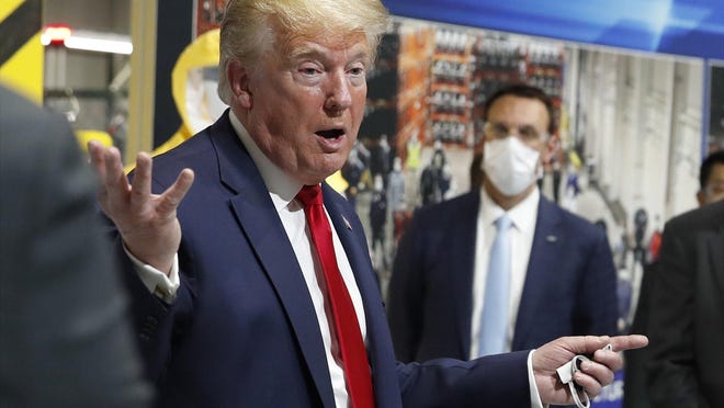 President Donald Trump, shown last month, holds a face mask in his left hand as he speaks during a May 21 tour of Ford's Rawsonville Components Plant in Ypsilanti, Mich., that has been converted to making personal protection and medical equipment.