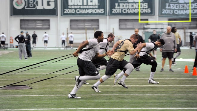 Michigan State linebackers pull against a resistance system during team conditioning in East Lansing on March 3, 2015.