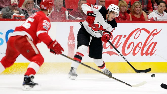 New Jersey Devils center Nico Hischier (13), of Switzerland, passes the puck against Detroit Red Wings defenseman Mike Green (25) during the first period of an NHL hockey game Saturday, Nov. 25, 2017, in Detroit.