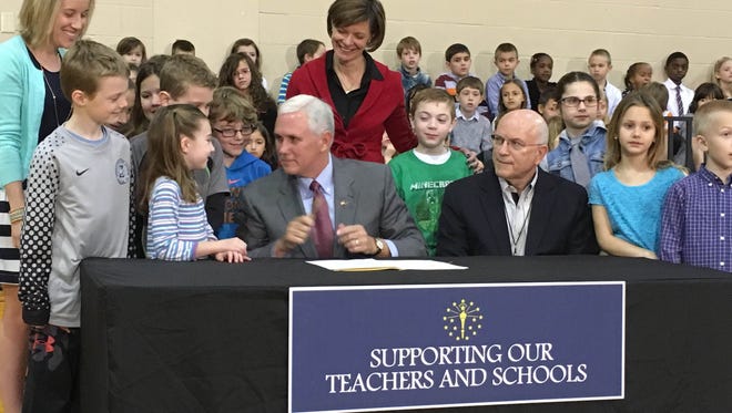 Gov. Mike Pence signs the bill that ends ISTEP by July 2017 while surrounded by children at Eagle Elementary School in Zionsville on March 22.