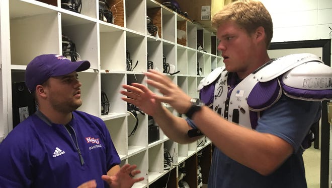 True freshman offensive lineman Lawson Scott, a Shreveport-Byrd product, tests the fit of his just-issued shoulder pads with Northwestern State head equipment manager Cody Crump on Wednesday. Scott and other newcomers were fitted for equipment as Demon football players reported for the start of preseason camp.
