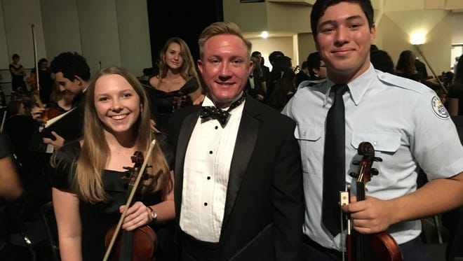 Violinist and soprano Samantha Kmetz and violinist Ezekiel DosSantos flank Jason Hobratschk, artistic director of the choral society and choir director and organist at St. Augustine of Canterbury Episcopal Church.