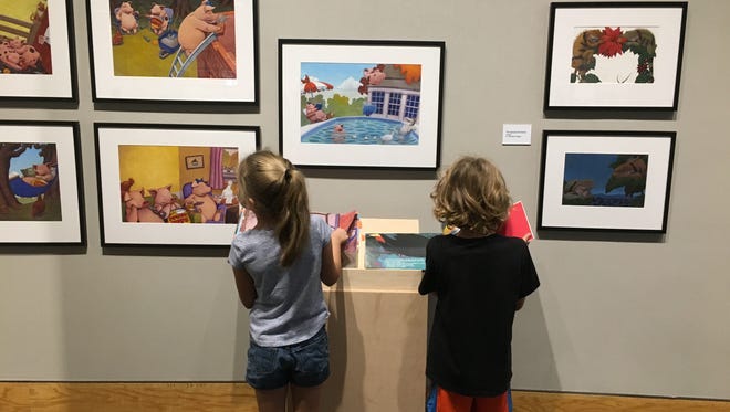 Children examine the art of Mark Teague at the National Center for Children’s Illustrated Literature during a school tour.