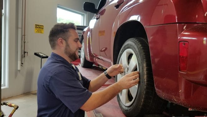 Automotive technology student Scott Jordan of Branchburg checks the wheel on a car at the Workforce Training Center, which officially opened May 23 at Raritan Valley Community College in Branchburg.