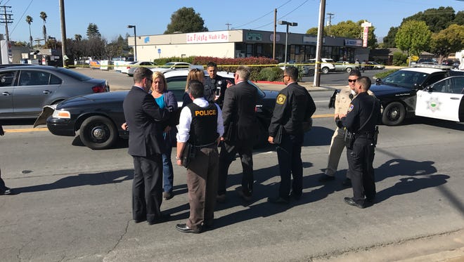 Investigators from the District Attorney's office speak with police officers and witnesses regarding the incident.