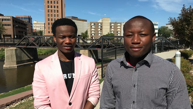 Brothers Nelson Nitunga (right) and Wilson Kubwayo pose for a portrait. Nitunga co-founded a charity that is helping children back in his native Burundi.