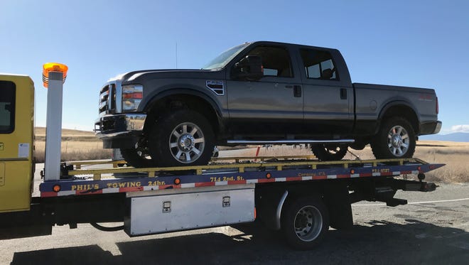 A tow truck removes a pickup with bullet holes in its side from Rancho Tehama on Tuesday. A shooter killed at least four people in a mass shooting in the Tehama County subdivision.