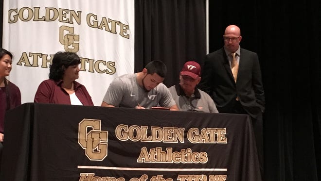 Golden Gate High School long snapper Oscar Shadley signs with Virginia Tech in the school's auditorium on Wednesday, Dec. 20, 2017. With Shadley are (from left) sister Marinna Shadley, mom Margarita Shadley, dad Gerry Shadley and Titans coach Mike DiGrigoli