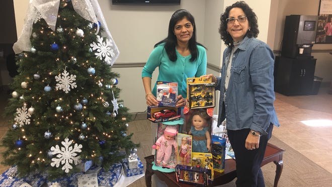 Manjali Shahi, left, of ConnectOne Bank and Barbara McCloskey of the Denville/Rockaway Woman’s Club collect several of the gifts that were distributed to local children this past holiday season.